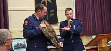 A person in uniform holding a case and a person in uniform holding a microphone

AI-generated content may be incorrect.